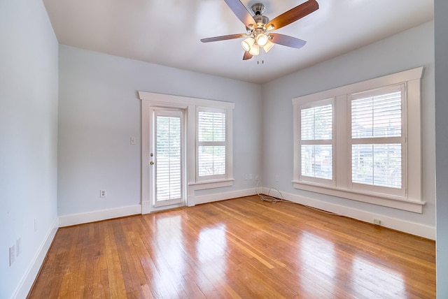 unfurnished room featuring light wood-style floors, baseboards, and a wealth of natural light