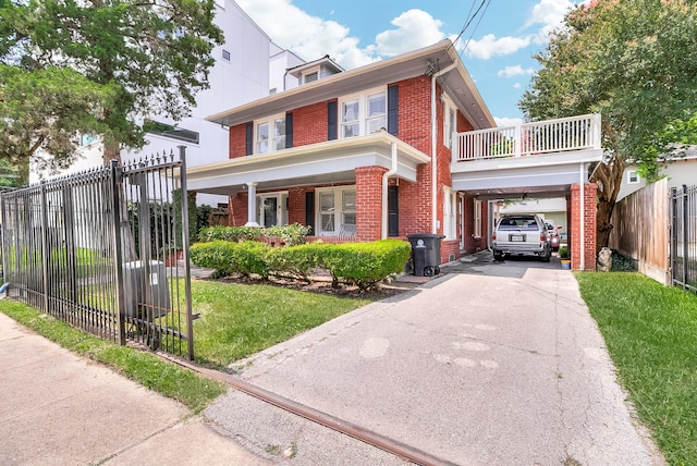 american foursquare style home with a front lawn, aphalt driveway, a carport, fence, and brick siding