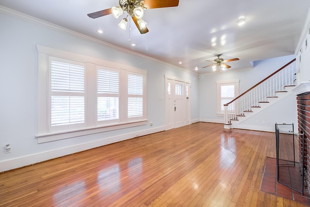 entryway with light wood-type flooring, ornamental molding, stairway, baseboards, and ceiling fan