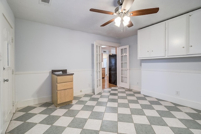 interior space with french doors, baseboards, visible vents, and a ceiling fan