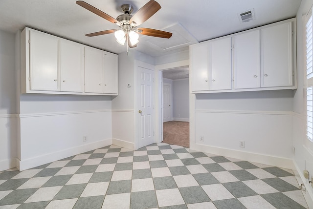 interior space with visible vents, baseboards, and ceiling fan