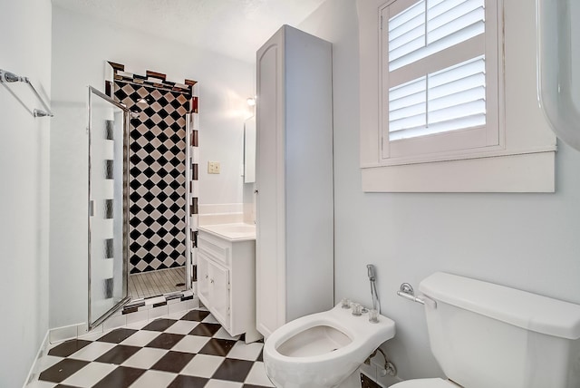 bathroom featuring tile patterned floors, toilet, a stall shower, a bidet, and vanity