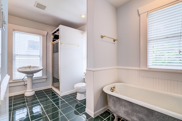 full bath featuring visible vents, a freestanding tub, a stall shower, tile patterned floors, and toilet