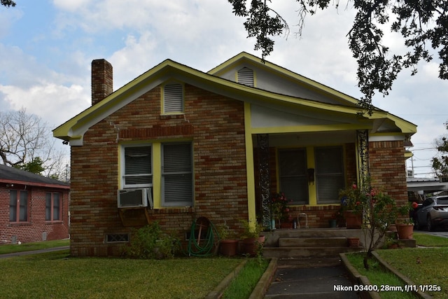 view of front of home with brick siding, cooling unit, a porch, and a front lawn