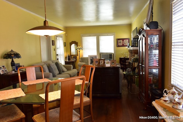 dining area with ornamental molding and dark wood-style flooring