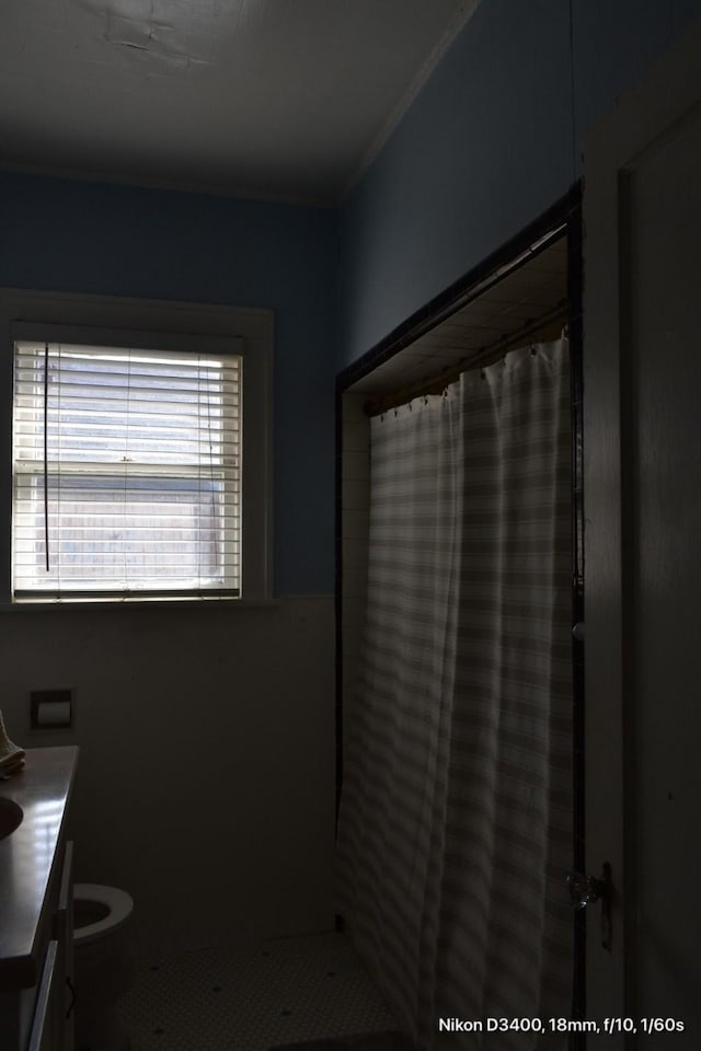 full bath featuring a shower with shower curtain, toilet, and vanity