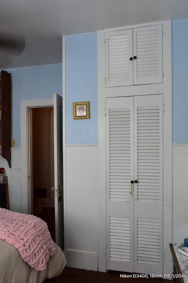 bedroom featuring a closet and wainscoting