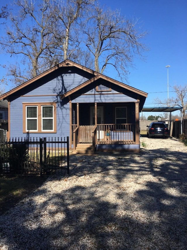 bungalow-style home featuring covered porch and a fenced front yard