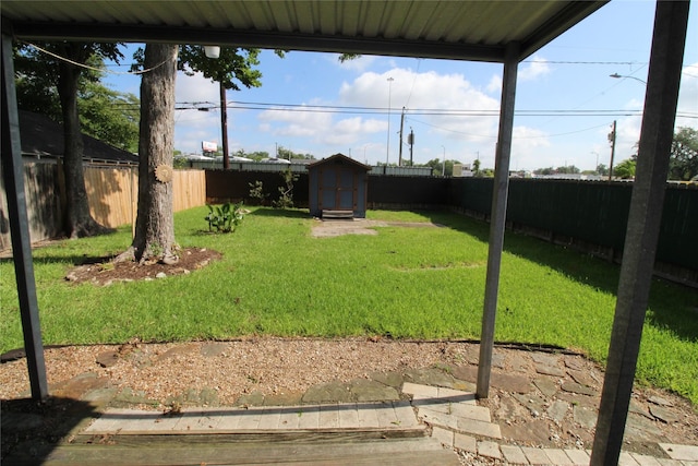 view of yard with an outdoor structure, a storage unit, and a fenced backyard