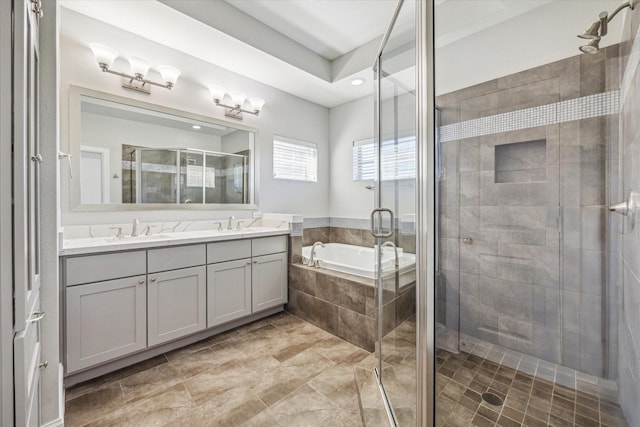 bathroom featuring double vanity, a stall shower, a garden tub, and a sink