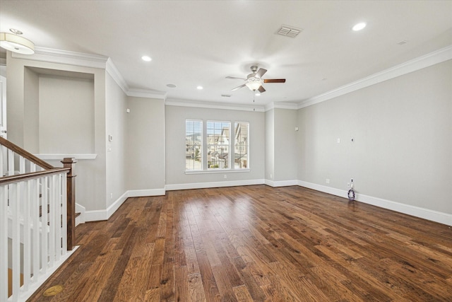 unfurnished room with dark wood finished floors, visible vents, baseboards, and ornamental molding