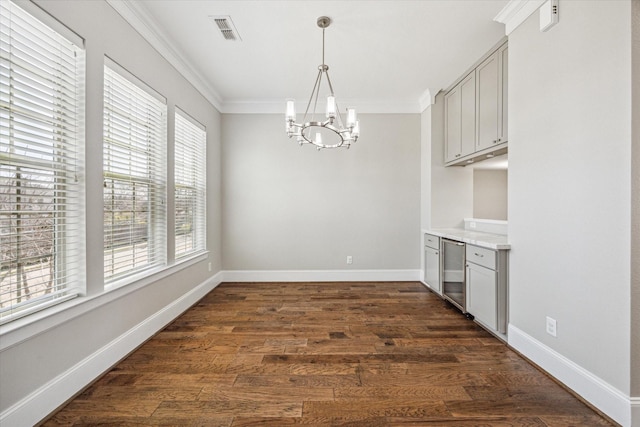 unfurnished dining area featuring visible vents, crown molding, and dark wood-type flooring