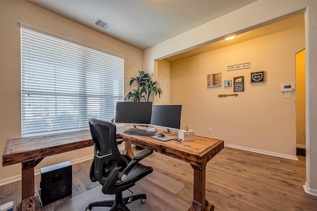 office area featuring visible vents, baseboards, and wood finished floors