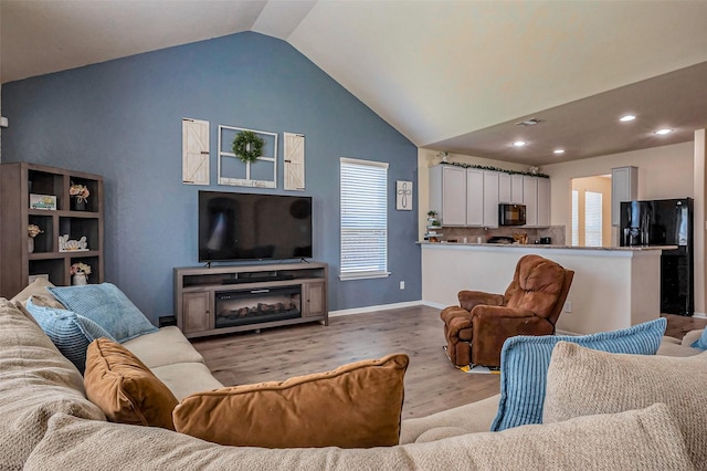 living room featuring wood finished floors, visible vents, baseboards, high vaulted ceiling, and recessed lighting