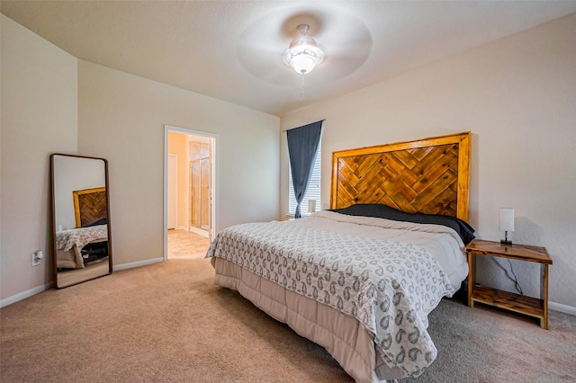 bedroom featuring light carpet, connected bathroom, a ceiling fan, and baseboards