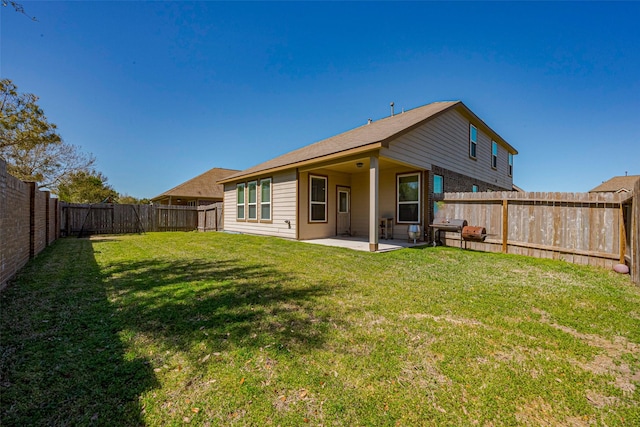 back of property with a yard, a patio area, and a fenced backyard