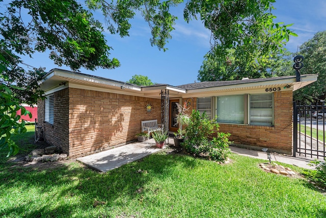 single story home featuring a front yard and brick siding