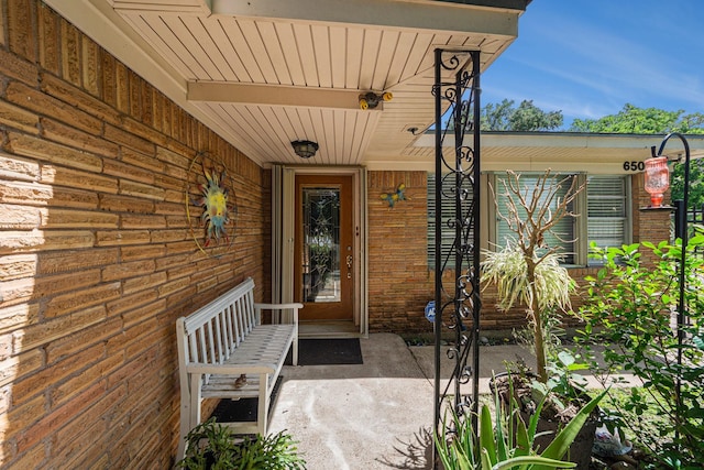 doorway to property featuring brick siding