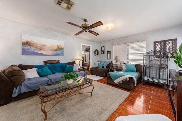 living area with a ceiling fan, wood finished floors, and visible vents