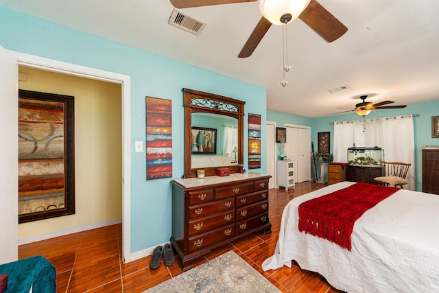 bedroom featuring visible vents, baseboards, dark wood-type flooring, and ceiling fan