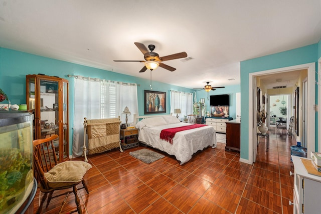 bedroom featuring dark tile patterned flooring, a ceiling fan, and visible vents