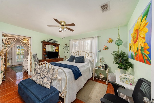 bedroom with access to exterior, visible vents, ceiling fan, and wood finished floors