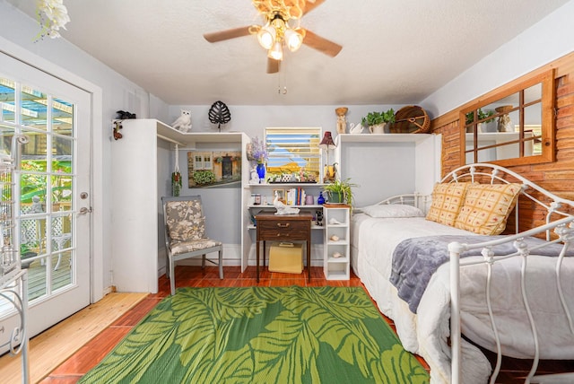 bedroom with a ceiling fan, access to outside, and wood finished floors