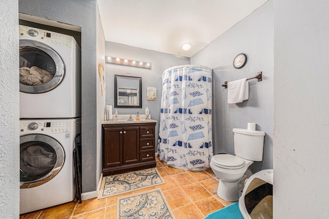 bathroom featuring toilet, curtained shower, tile patterned flooring, stacked washer / drying machine, and vanity