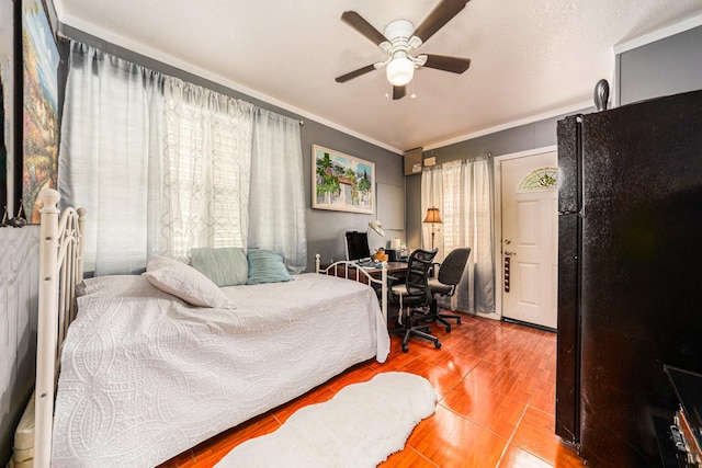 bedroom with crown molding, freestanding refrigerator, and a ceiling fan