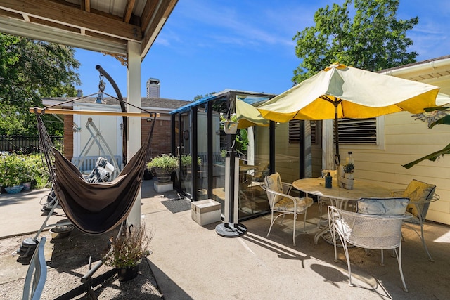 view of patio with outdoor dining space and fence