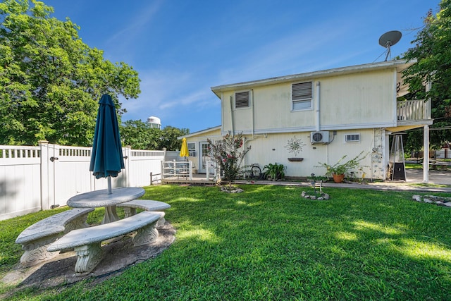 rear view of property featuring a yard and fence