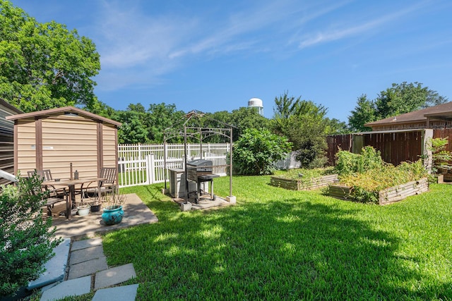 view of yard featuring a garden, a fenced backyard, an outdoor structure, a storage shed, and a patio area