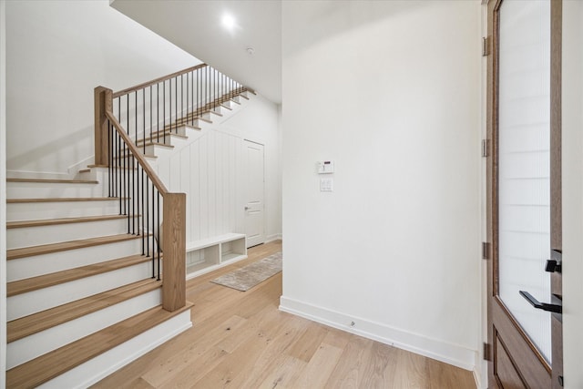 staircase with baseboards and wood finished floors