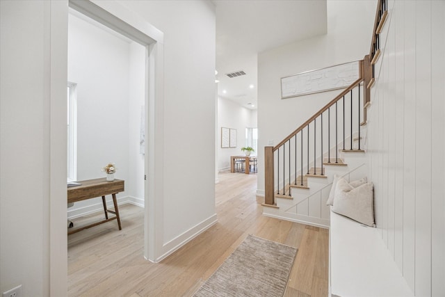 foyer featuring visible vents, baseboards, stairway, light wood-type flooring, and recessed lighting