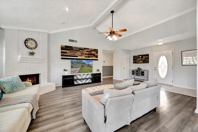 living area with a brick fireplace, baseboards, and wood finished floors