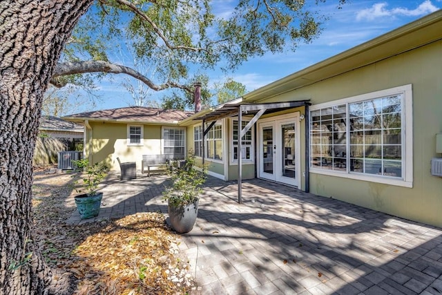 exterior space with central air condition unit, a patio area, fence, and french doors