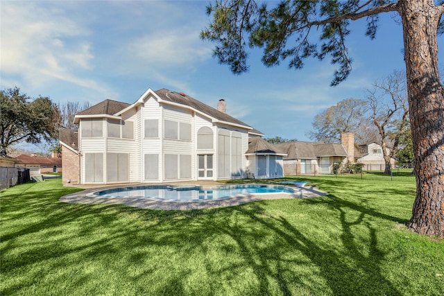 rear view of house with a lawn, a fenced backyard, and a chimney