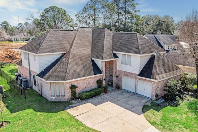 view of front of house featuring fence, driveway, a chimney, a front lawn, and brick siding