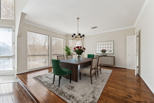 dining area with a chandelier, visible vents, ornamental molding, and dark wood-style flooring