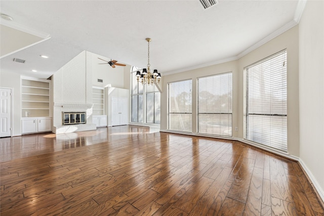 unfurnished living room with visible vents, built in shelves, hardwood / wood-style floors, and a fireplace