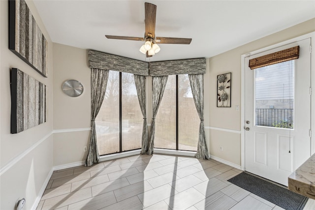 interior space featuring baseboards and ceiling fan