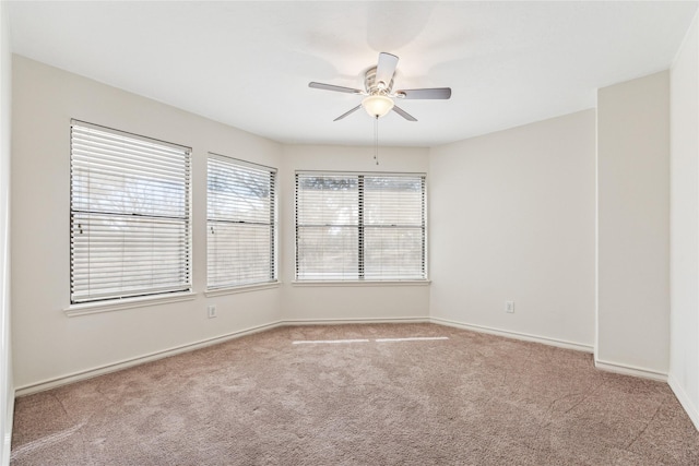 carpeted spare room with baseboards and ceiling fan