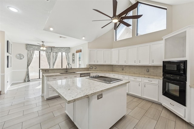 kitchen with black appliances, a sink, tasteful backsplash, a center island, and a peninsula