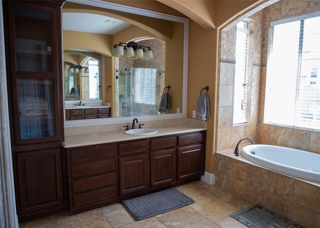 bathroom featuring a garden tub, a stall shower, and vanity