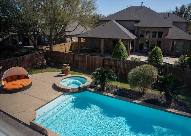 view of pool featuring a patio area, a pool with connected hot tub, and a fenced backyard