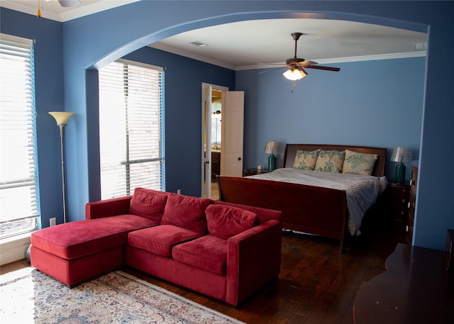 bedroom featuring wood finished floors, visible vents, arched walkways, and ornamental molding