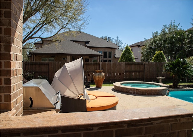 view of pool with an in ground hot tub, a fenced backyard, a fenced in pool, and a patio area