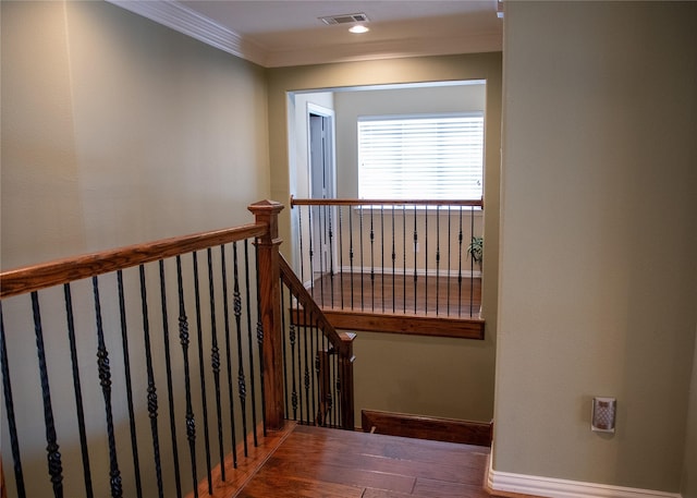 stairs featuring visible vents, wood finished floors, and ornamental molding