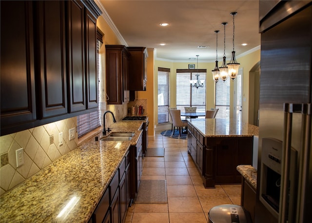 kitchen featuring a sink, premium appliances, tasteful backsplash, light tile patterned flooring, and light stone countertops