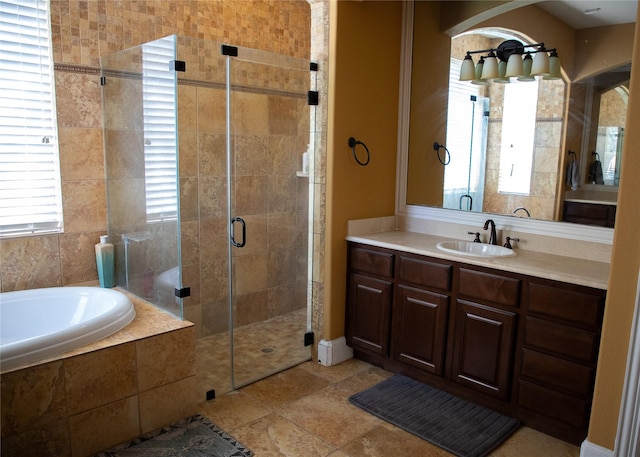 bathroom with a stall shower, vanity, and a garden tub